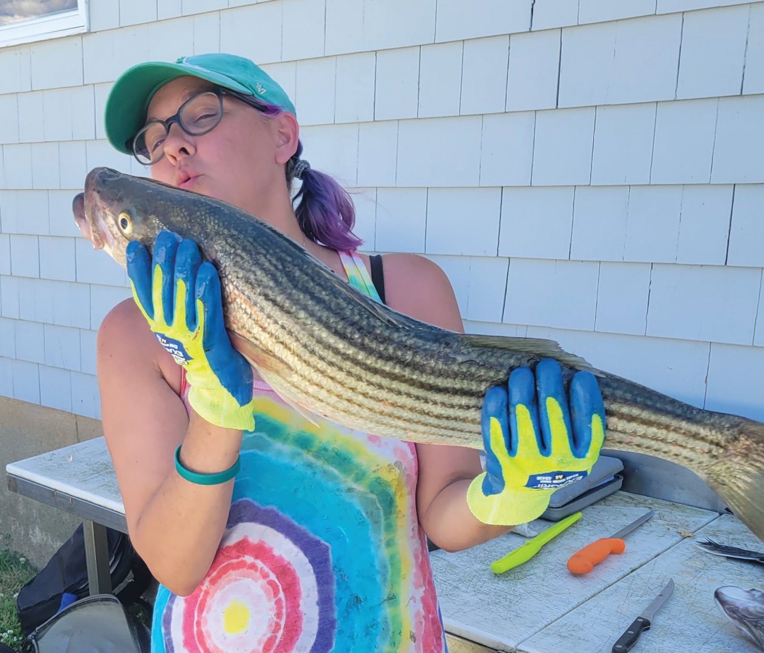 FIRST KEEPER: Katie Spier showing appreciation for the first keeper bass she caught off the Sakonnet River when fishing with her uncle Greg Spier.